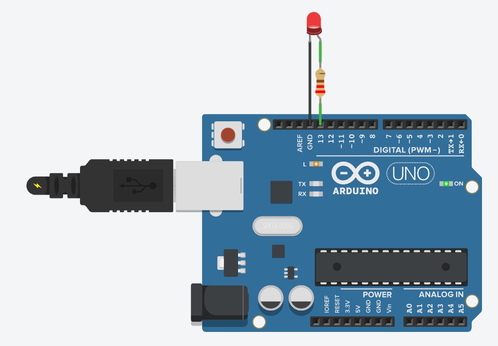 Photo: Arduino with a breadboard LED lit, laptop showing the Arduino IDE